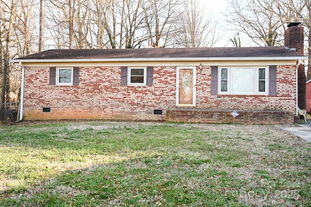 ranch-style house featuring a chimney, a front yard, brick siding, and crawl space