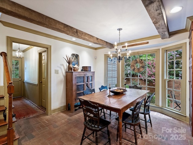 dining room with brick flooring, a chandelier, beam ceiling, baseboards, and healthy amount of natural light