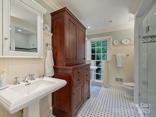 full bath featuring crown molding, a shower stall, a sink, and toilet