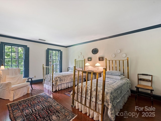 bedroom featuring ornamental molding, wood finished floors, and baseboards