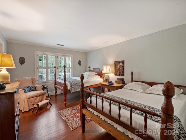 bedroom featuring hardwood / wood-style floors, ornamental molding, and baseboards