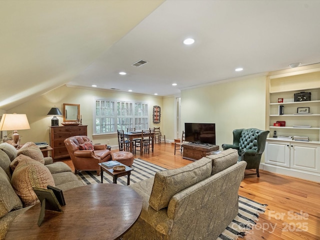living area with light wood finished floors, crown molding, and recessed lighting