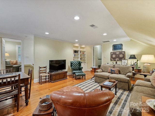 living room featuring wood finished floors, built in shelves, recessed lighting, and crown molding