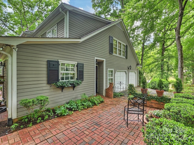 rear view of house with driveway and an attached garage