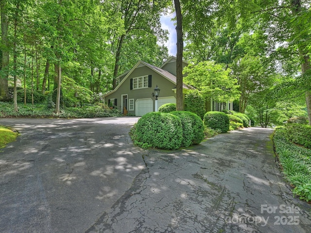 view of property exterior with asphalt driveway