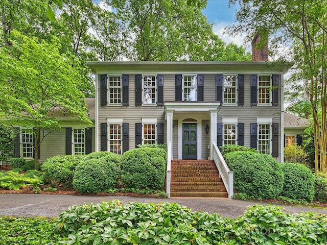 colonial inspired home featuring a chimney