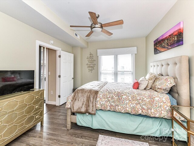 bedroom with visible vents, baseboards, ceiling fan, and wood finished floors