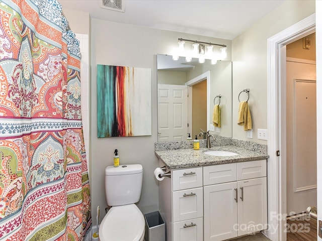 full bath featuring visible vents, a shower with curtain, toilet, and vanity
