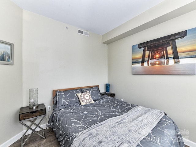 bedroom featuring visible vents, baseboards, and wood finished floors