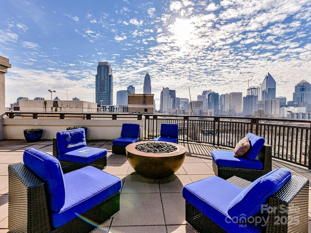 view of patio / terrace featuring a view of city and an outdoor living space with a fire pit