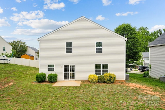 back of house featuring fence, a patio, a yard, and central AC