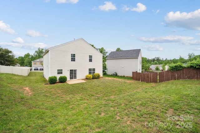 back of property with a lawn, fence, and a patio