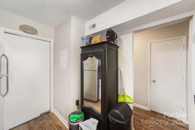 workout room with dark wood-type flooring, baseboards, and a textured ceiling