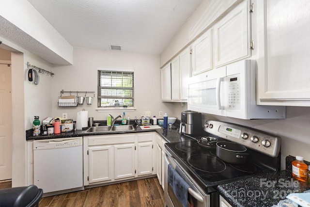 kitchen with white appliances, a sink, dark wood-type flooring, white cabinetry, and a textured ceiling