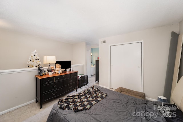 bedroom featuring light colored carpet, a closet, and baseboards