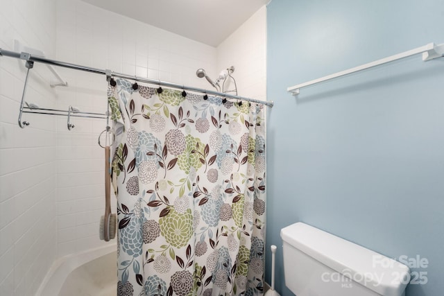 bathroom featuring a shower with curtain and toilet