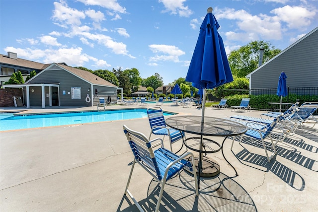 community pool featuring fence and a patio area