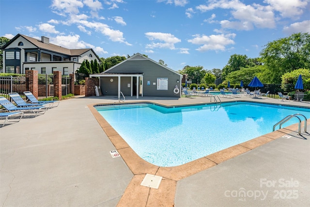 community pool featuring fence and a patio