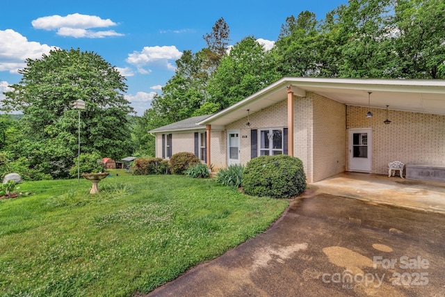 676 Arrowhead Trl Unit 6, Marion, NC 28752 - view of side of property featuring brick siding, a lawn, a carport, and concrete driveway