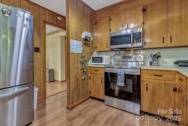 676 Arrowhead Trl Unit 6, Marion, NC 28752 - kitchen with appliances with stainless steel finishes, backsplash, light countertops, brown cabinets, and wood walls
