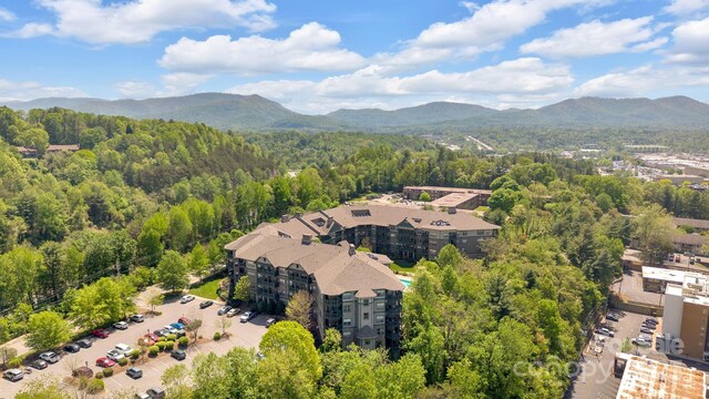birds eye view of property with a mountain view and a forest view