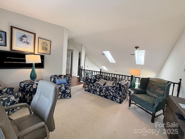 carpeted living area with vaulted ceiling with skylight