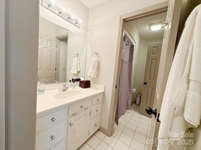full bath featuring a textured ceiling, tile patterned flooring, and vanity