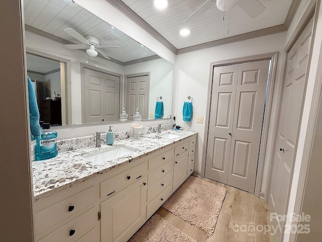 full bath with double vanity, a ceiling fan, and a sink