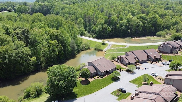 birds eye view of property featuring a forest view, a residential view, and a water view