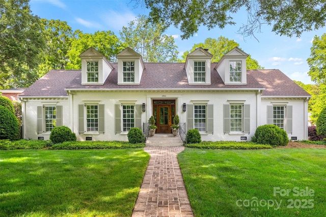 cape cod home featuring brick siding and a front yard