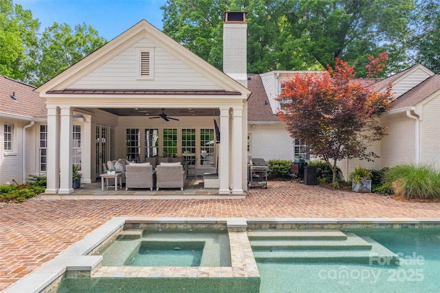 rear view of property with a patio area, a ceiling fan, a standing seam roof, an outdoor pool, and an outdoor hangout area
