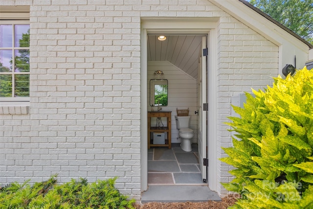 entrance to property featuring brick siding