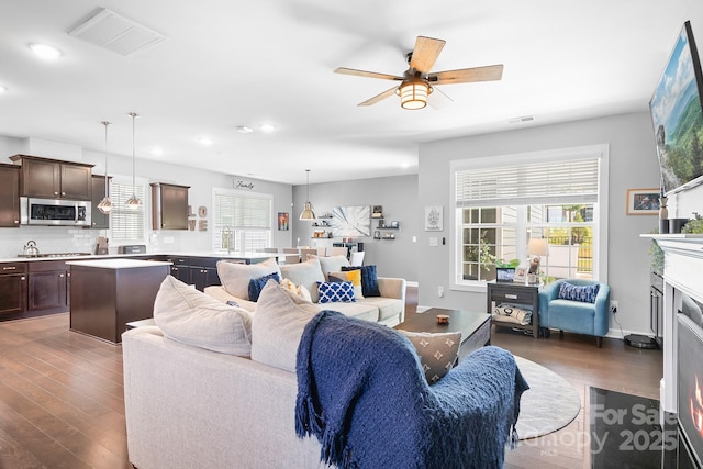 living area featuring dark wood-style flooring, a ceiling fan, recessed lighting, and a fireplace with flush hearth