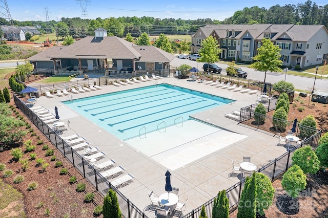community pool featuring fence and a residential view