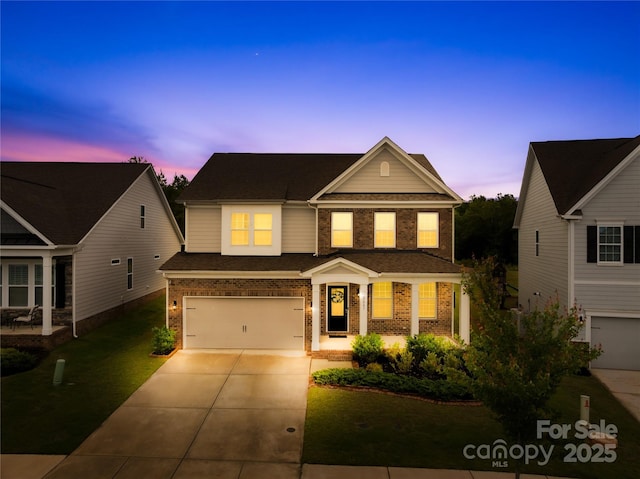 traditional-style home with brick siding, driveway, a garage, a lawn, and a shingled roof
