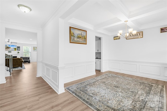 interior space featuring light wood finished floors, coffered ceiling, wainscoting, beamed ceiling, and ornamental molding