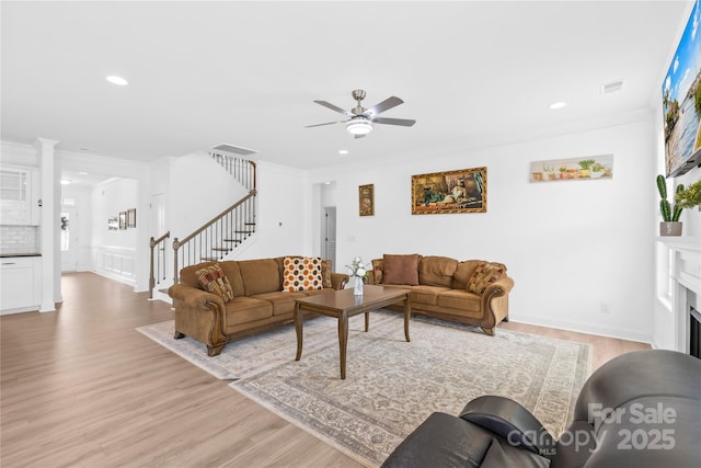 living room with a ceiling fan, stairs, light wood finished floors, and recessed lighting