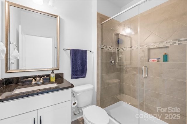 bathroom featuring vanity, toilet, and a shower stall