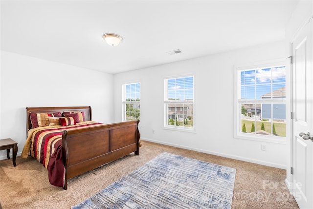 carpeted bedroom featuring baseboards and visible vents