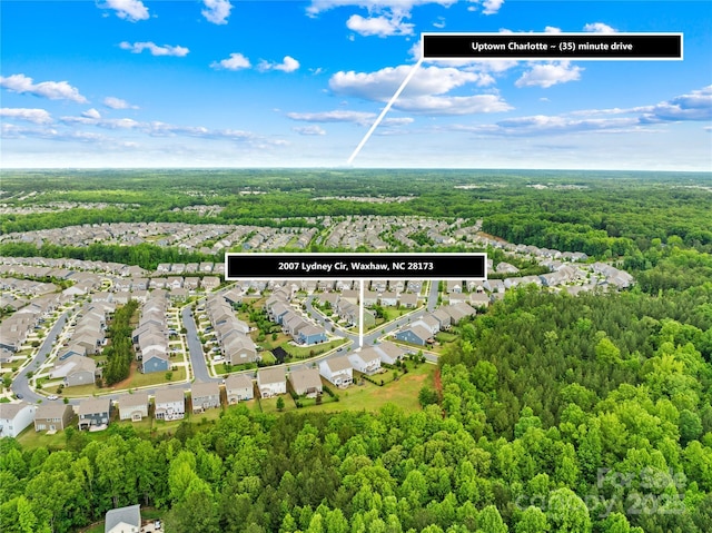birds eye view of property with a wooded view and a residential view