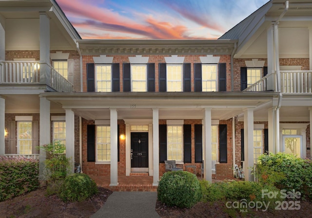 155 Harper Lee St, Davidson, NC 28036 - view of front facade with a balcony, covered porch, and brick siding