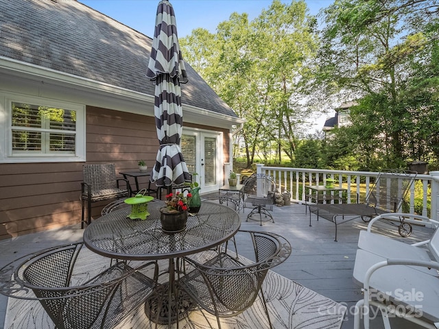 wooden deck featuring outdoor dining space and french doors