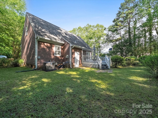 back of house featuring a deck, a yard, roof with shingles, and central AC unit