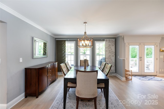 dining area with baseboards, an inviting chandelier, and light wood-type flooring