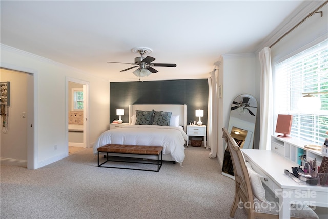 carpeted bedroom featuring a ceiling fan, baseboards, ornamental molding, and ensuite bath