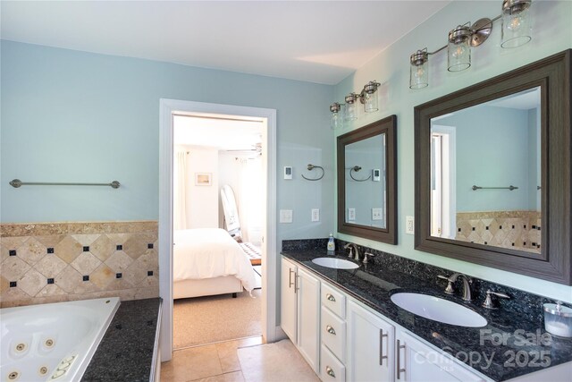 bathroom with tile patterned flooring, a sink, a whirlpool tub, and connected bathroom