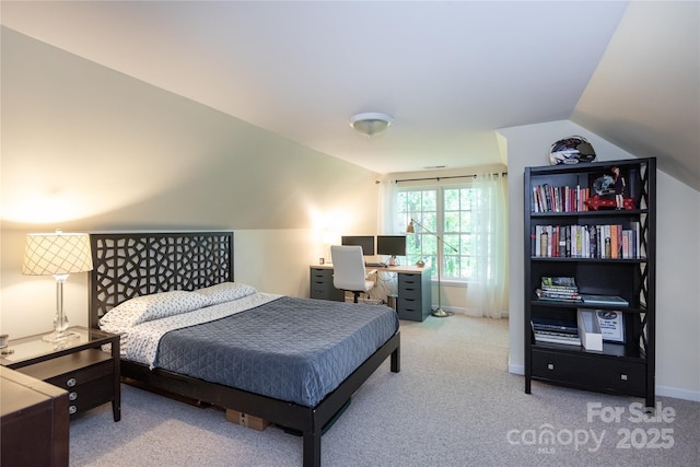 carpeted bedroom with baseboards and vaulted ceiling