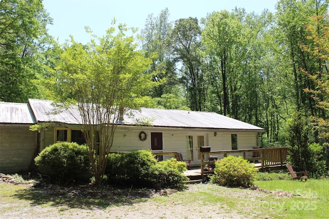 view of front facade with french doors, a deck, and metal roof
