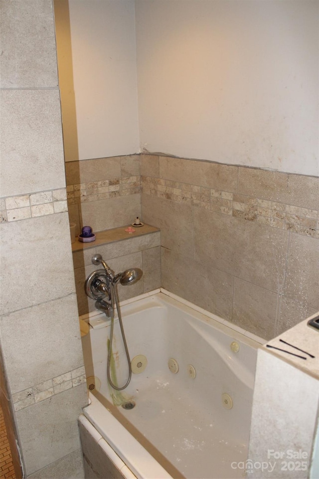 bathroom with tile walls and a jetted tub