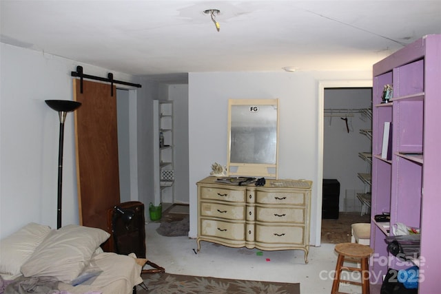 bedroom with a walk in closet, a closet, and a barn door